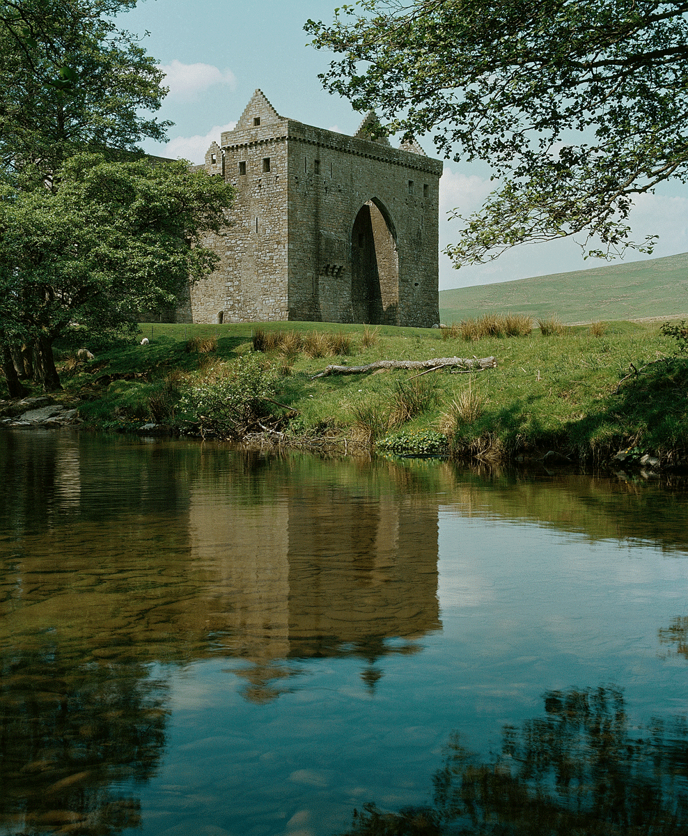 The main enterence of Hermitage Castle with its reflection in a nearby pond