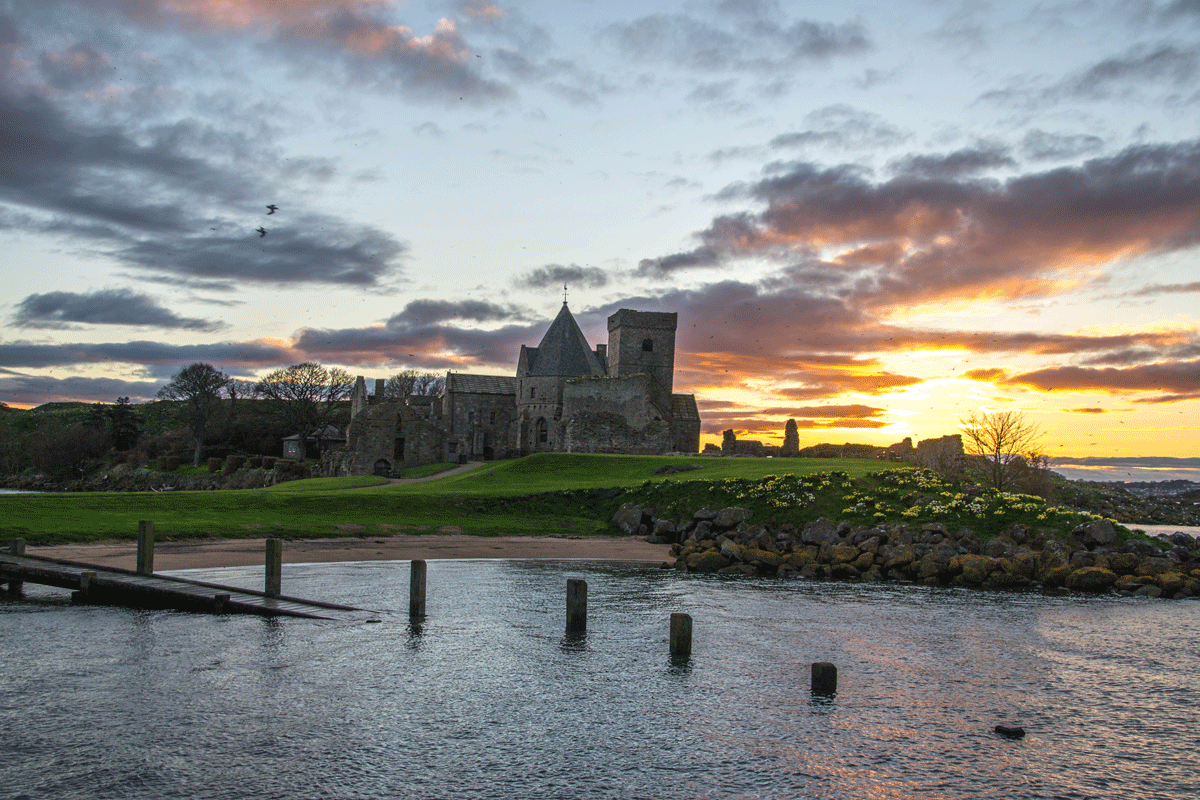 Inchcolm Abbey at sunset with partial view of jetty 