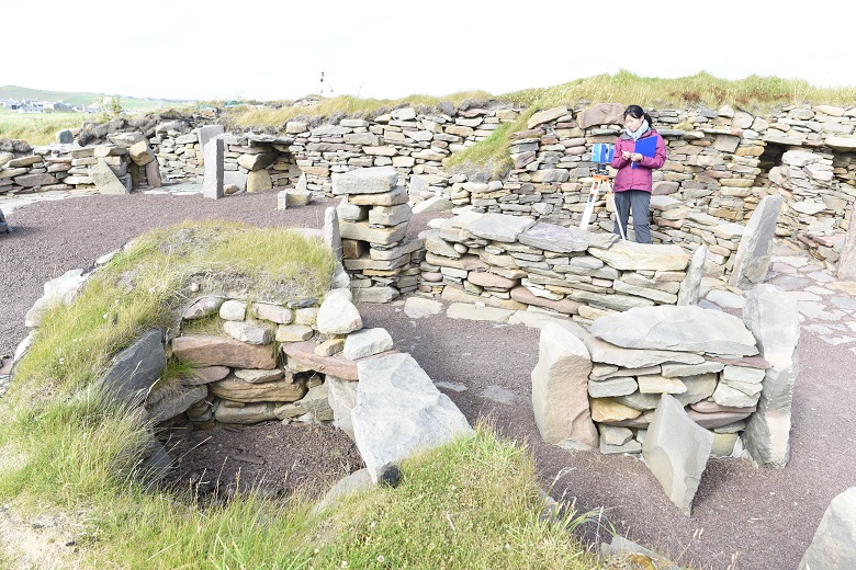 A person with a laser scanner at a historic site