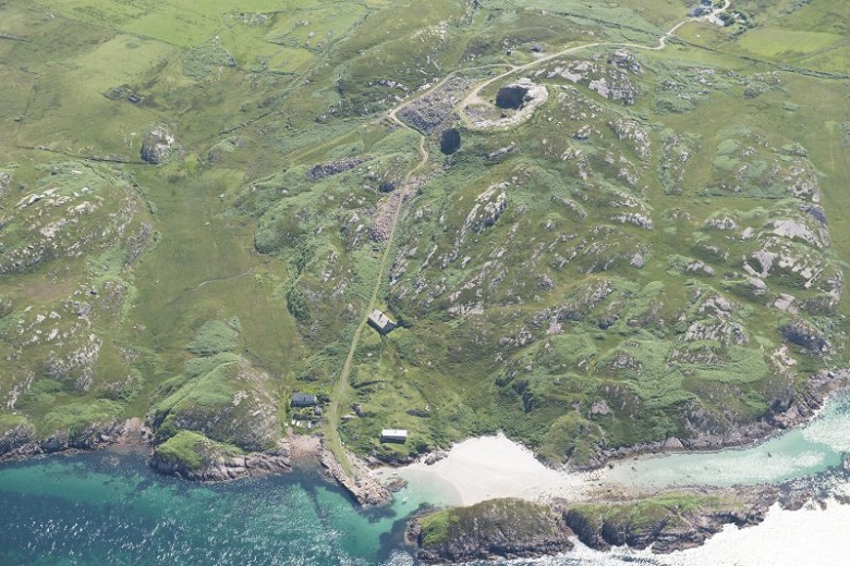 Aerial view of path leading from a sandy beach to a quarry