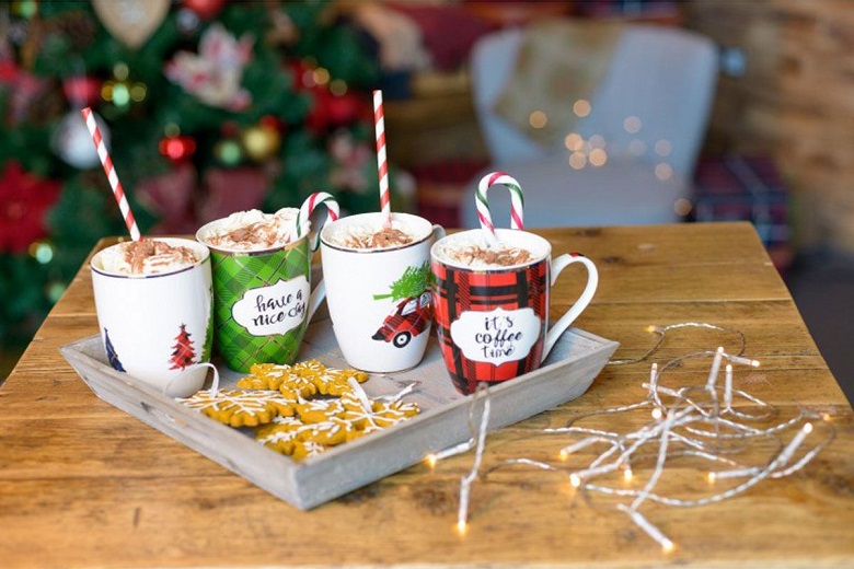 For Christmas themed mugs on a tray containing hot drinks