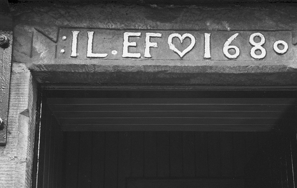 Black and white image of a lintel with the letters IL and EF and the date 1680