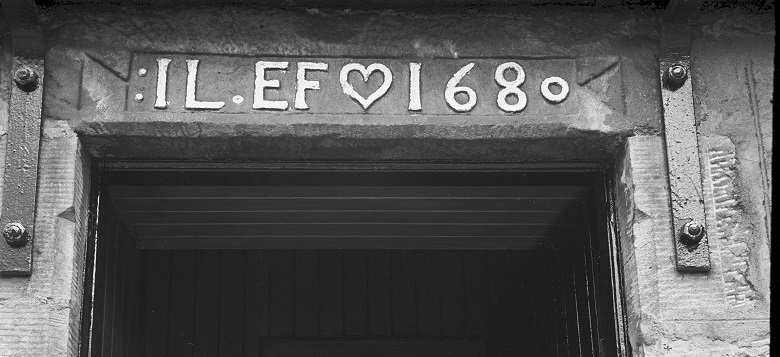 Black and white image of a lintel with the letters IL and EF and the date 1680