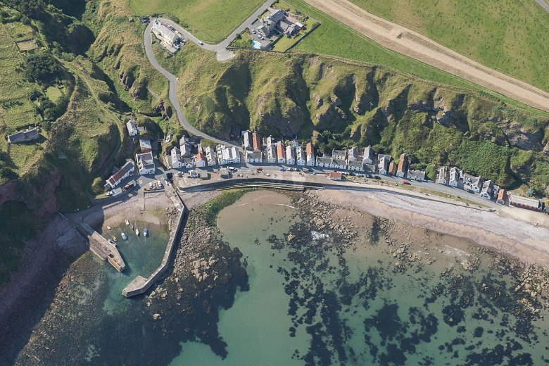 An aerial photo of a row of houses by the sea