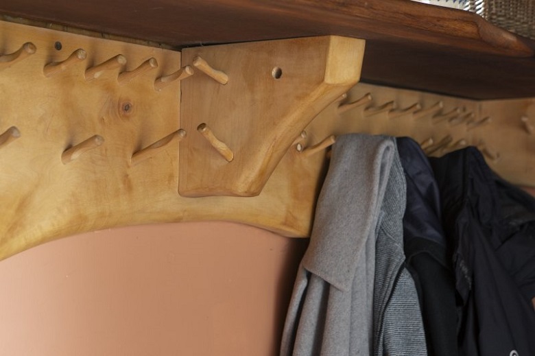 Hand-carved wooden coat pegs inside The Steading