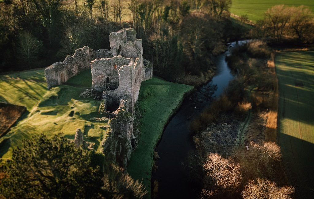 A drone photo of Hailes Castle beside a river