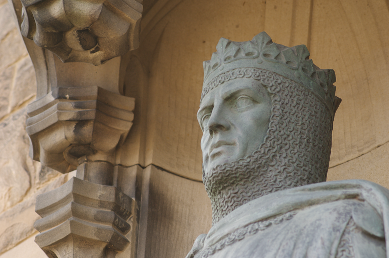 Close-up photo of a statue of Robert the Bruce wearing chainmail and a crown 