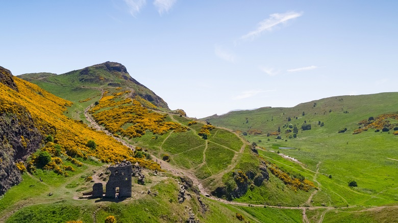 The ruins of a chapel with Arthur's Seat in the background