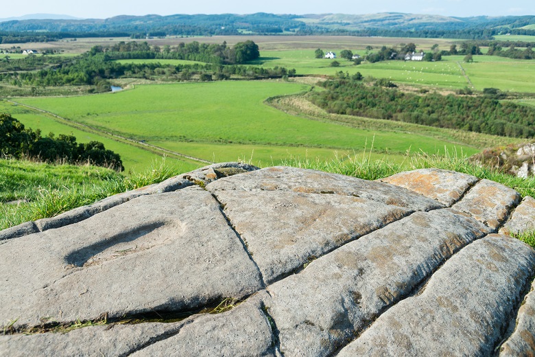 View across Kilmartin Glen from the top of Dunadd Hill Fort. Footsteps can be seen carved into the stone. 