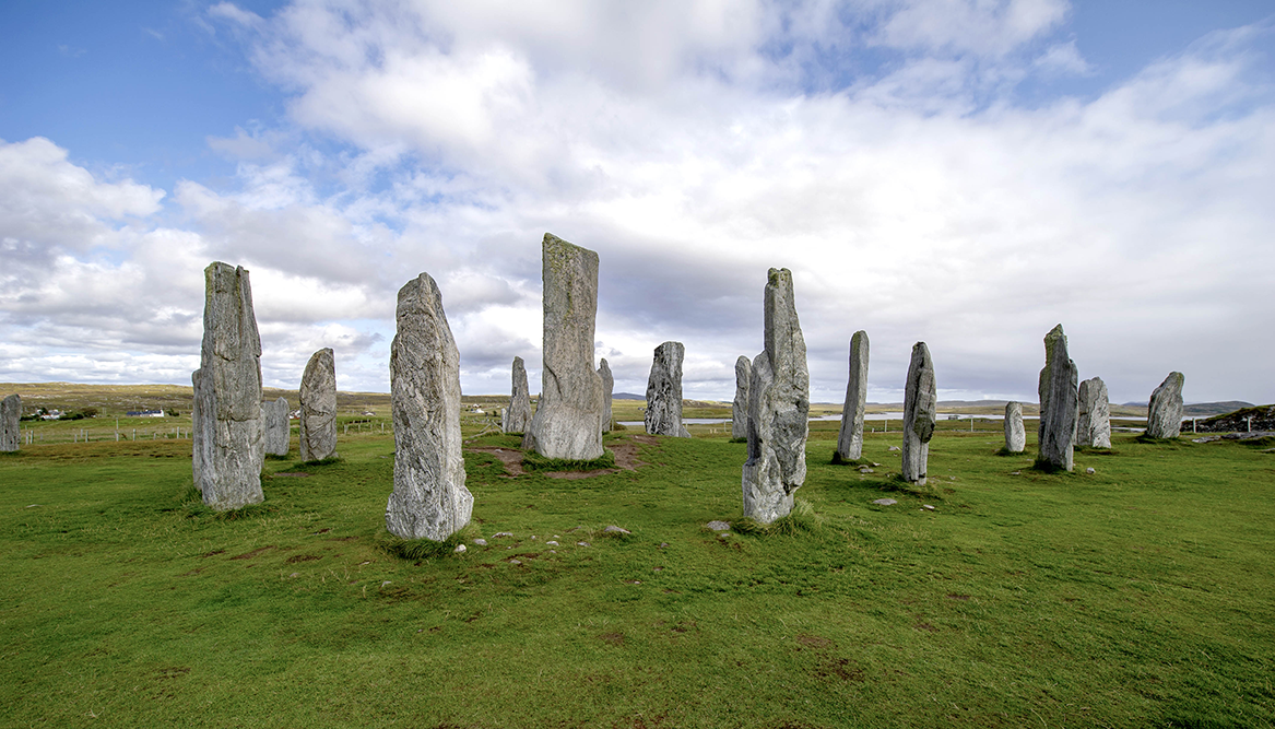 a line of standing stones on green grass