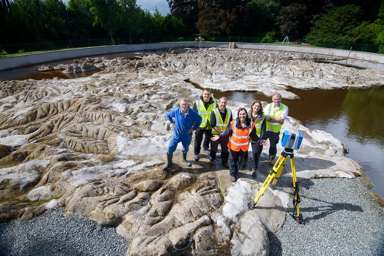 A team of HES staff working with a camera and a tripod on a large 3D map of Scotland