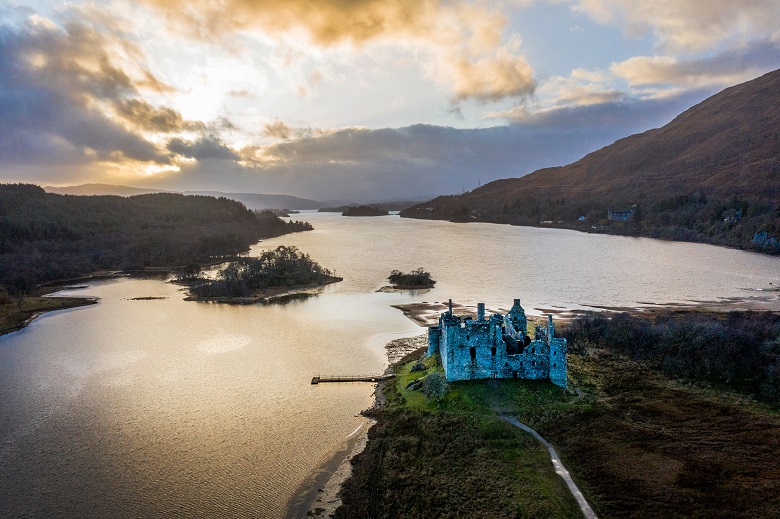 An aerial view of Kilchurn Cstle and Loch Awe as sun breaks through the clouds