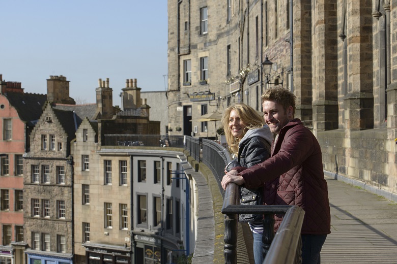 A couple smiling and laughing as they explore Edinburgh's Old Town