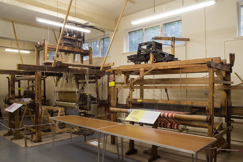 Two wooden looms on display in a museum 