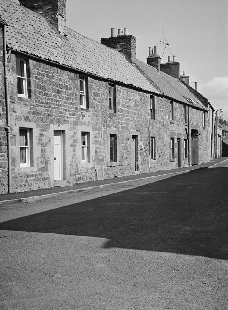 Row of small, two storey cottages.