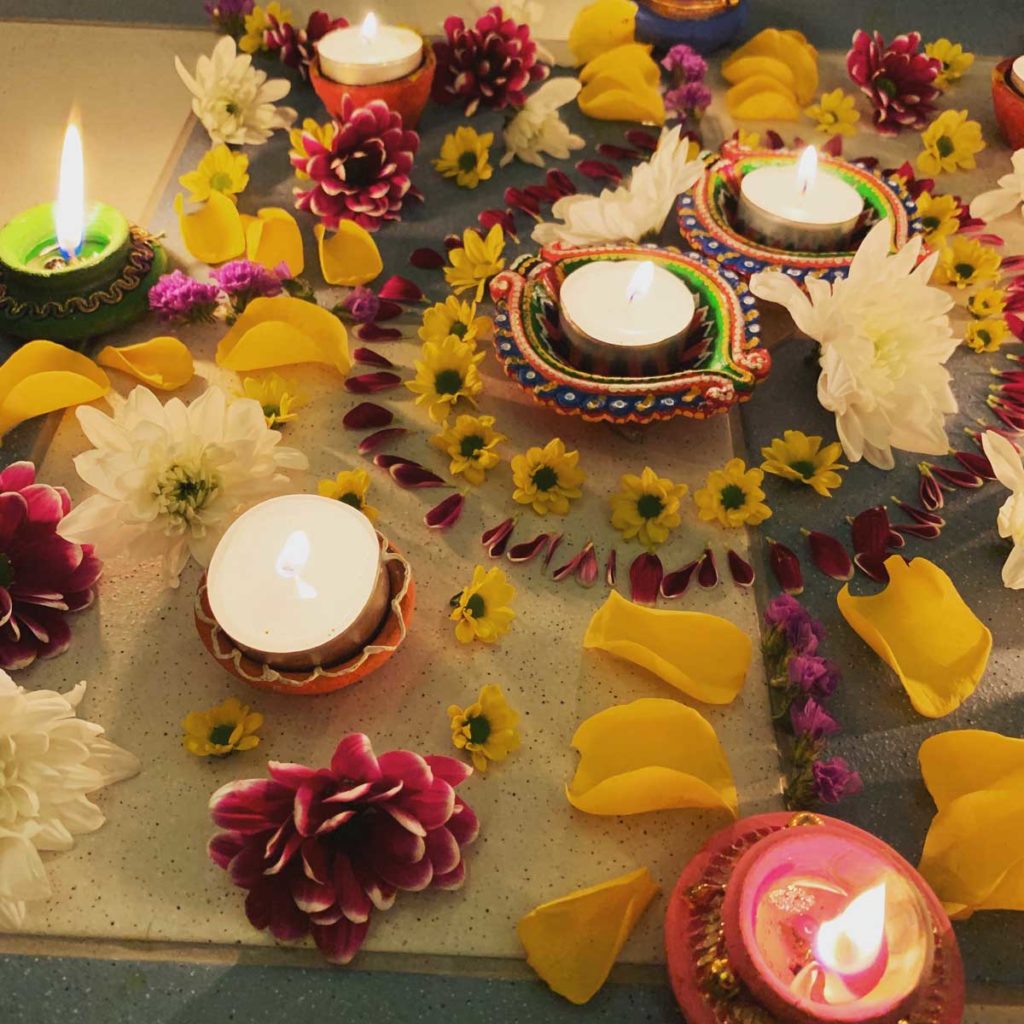 Flower petals laid out in a pattern around tea lights