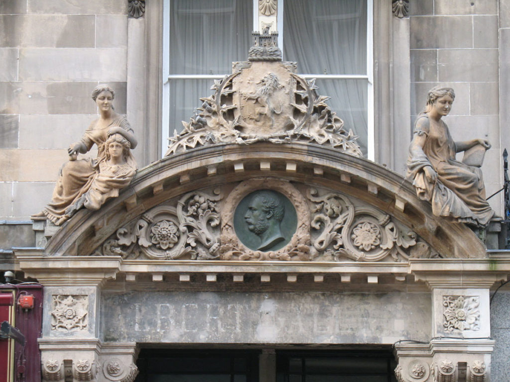 Ornate decorations above a doorway. The words "Albert Hall" can faintly be read above the door.
