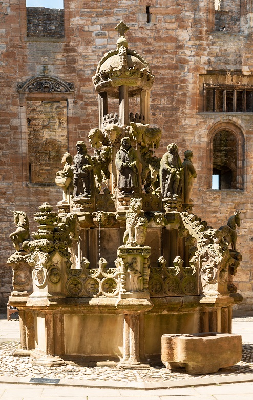 An ornately carved stone fountain in the courtyard of a palace