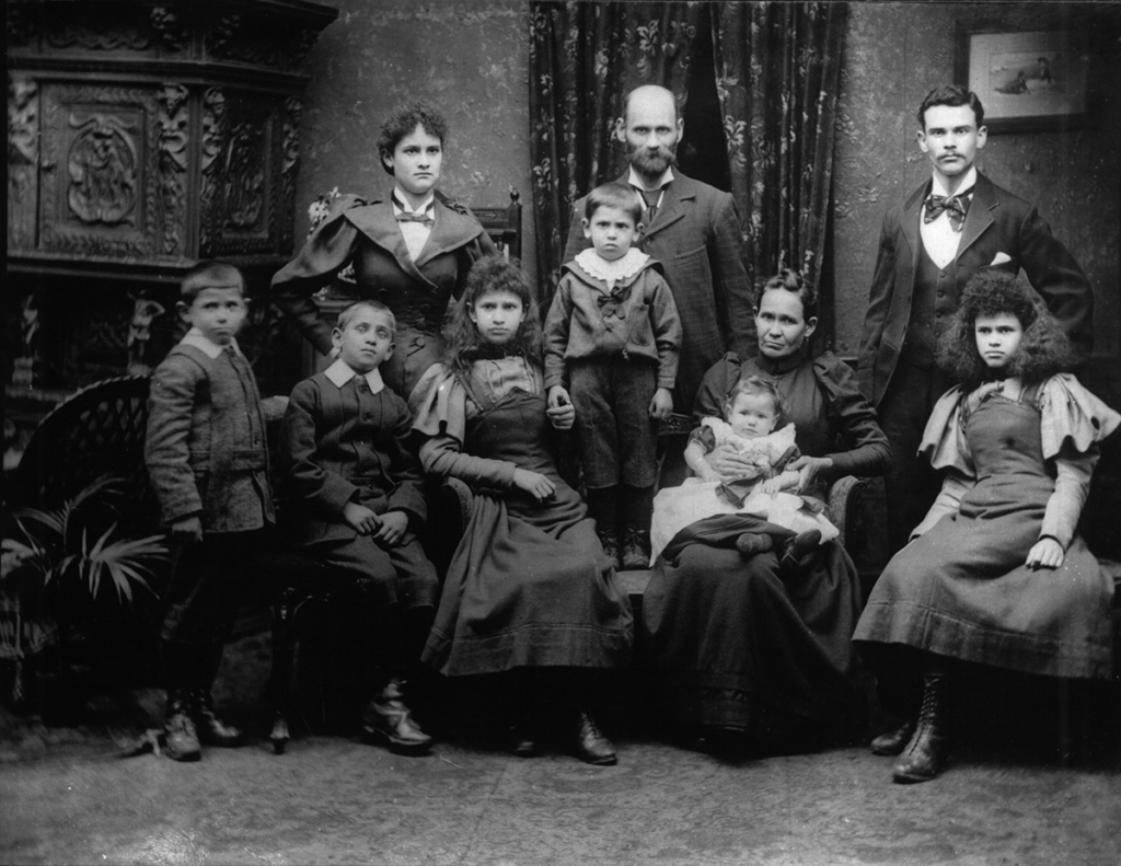 A family group of four adults and six children wearing Victorian clothing and looking at the camera
