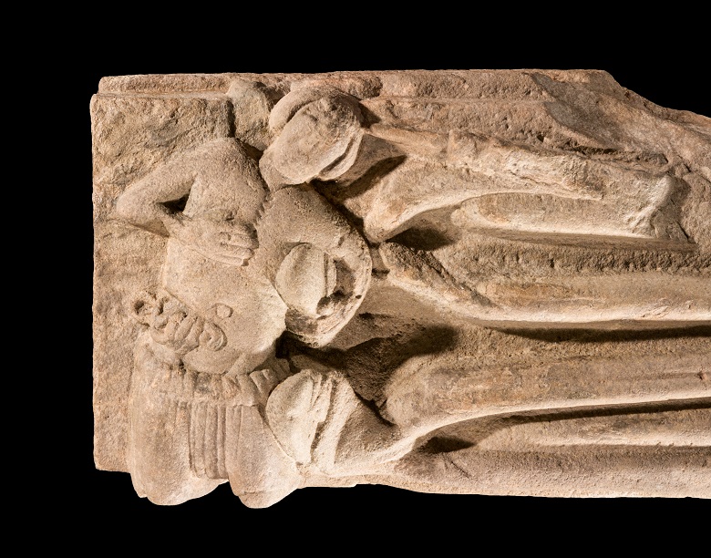 close up of a small carved figure at the feet of the abbot