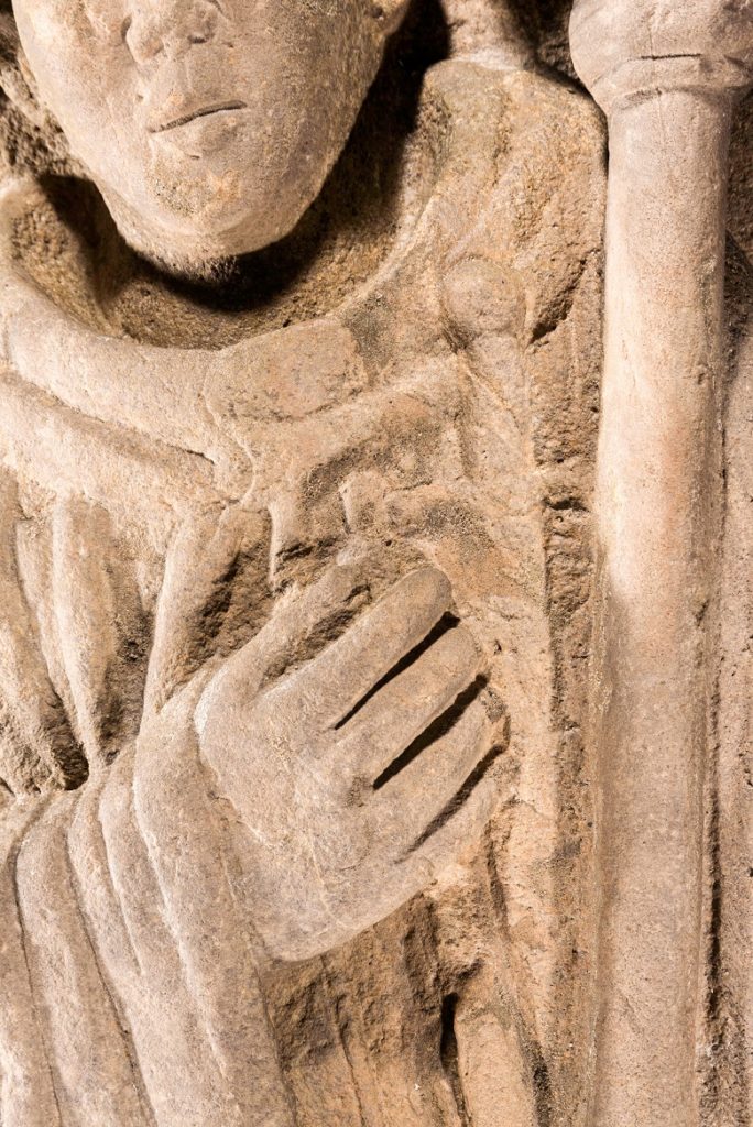 close up of the carving showing the detail of the carved hand and dagger