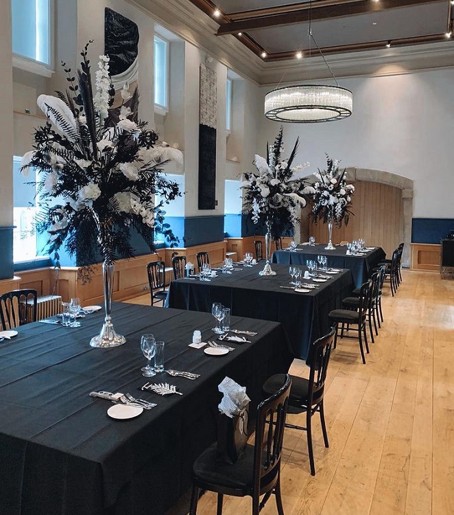 table laid for a meal with elaborate flower decoration in the centre