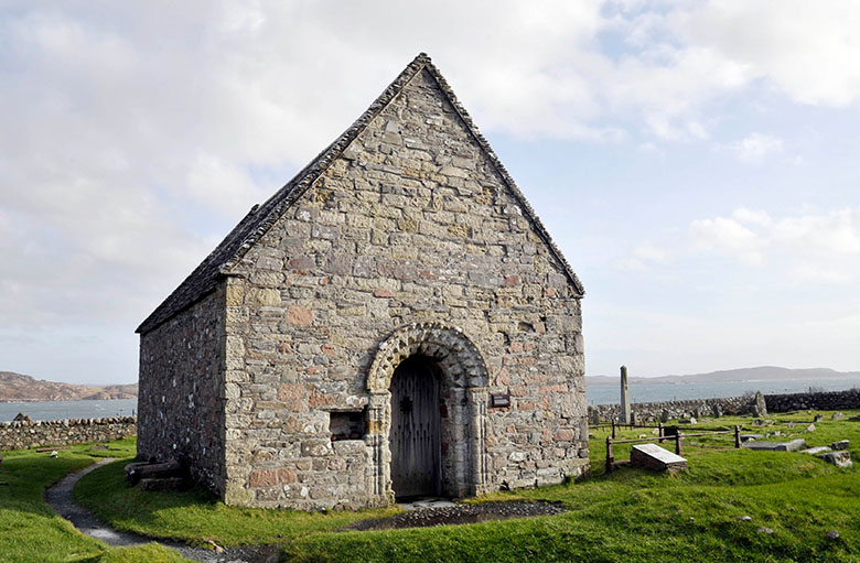 a small stone chapel with a decoratively carved romanesque arch