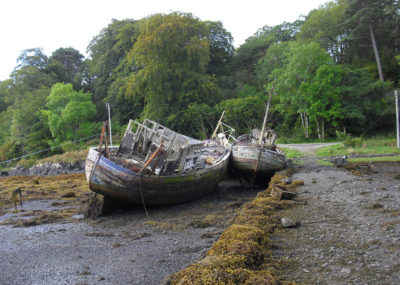 Abandoned fishing boats beside a loch