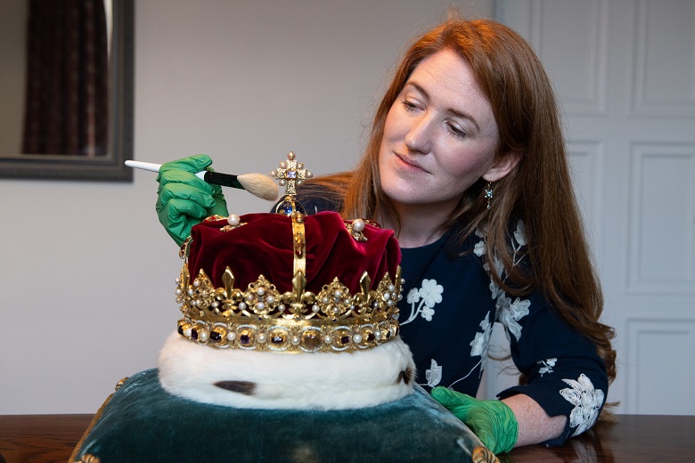 A conservator carefully cleaning a crown