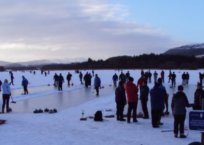 People stand on a frozen lake to play curling