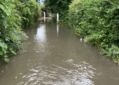 A path entirely overwhelmed by water, looking more like a canal than a walkway