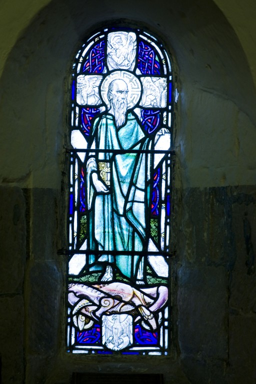Photo of a stained glass window depicting a man in robes 