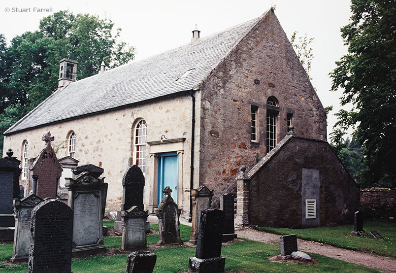 A small, plain, stone built kirk, surrounded by grave stones.