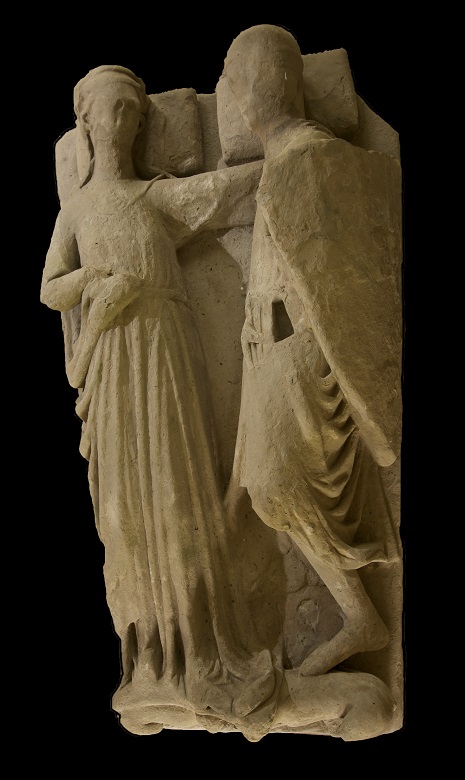 A stone effigy with carvings of two figures, a husband and wife, in an embrace