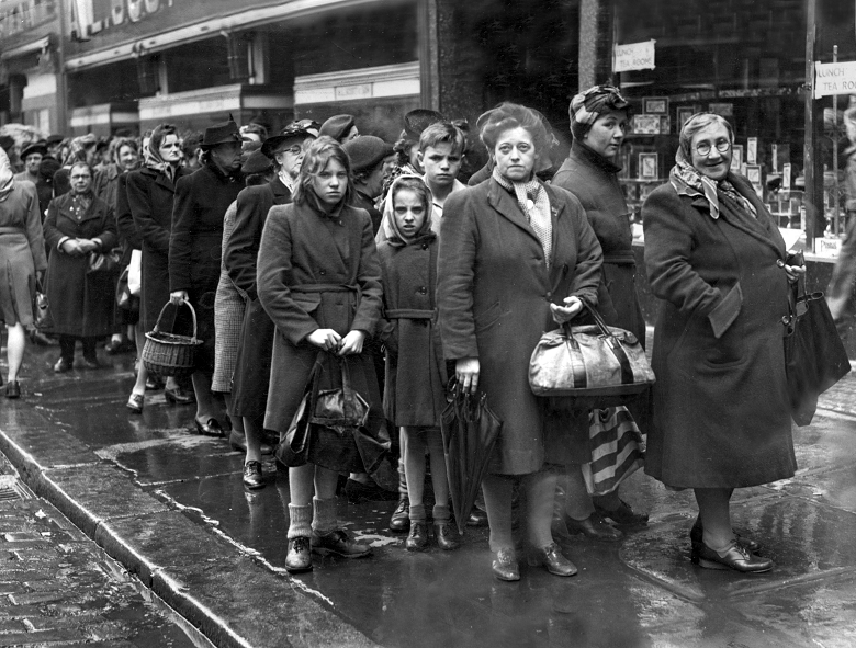 An archive photo showing people waiting in a ration queue on a city street