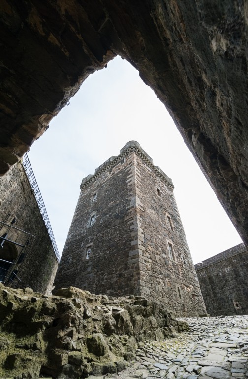 A view of a castle tower through a stone doorway