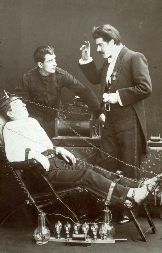A black and white photo showing Walford Bodie hypnotising a person in the famous electric chair.