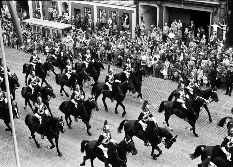 An archive photo of cavalry riding through Edinburgh as crowds look on