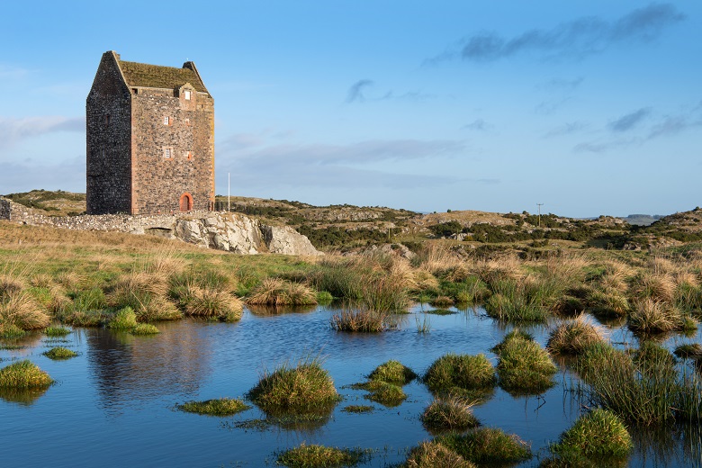 A small loch or pond in front of a remote, hilltop tower house. This spot inspired Walter Scott's love of Border Ballads