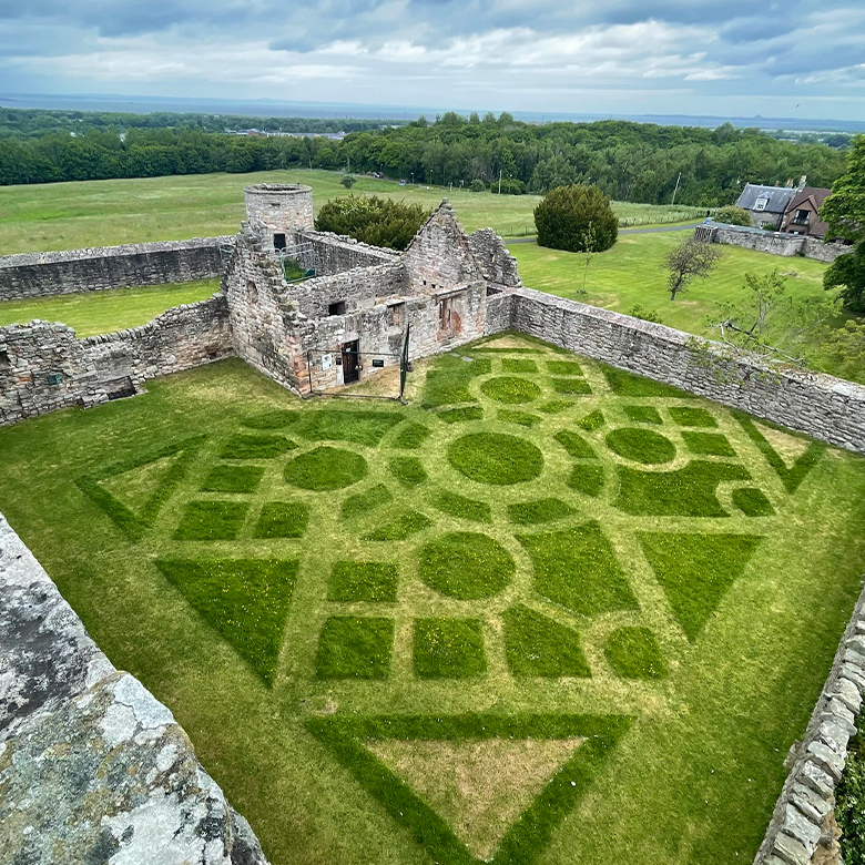 View of the gardens at Craigmillar Castle, where a formal design has been mowed into the grass.