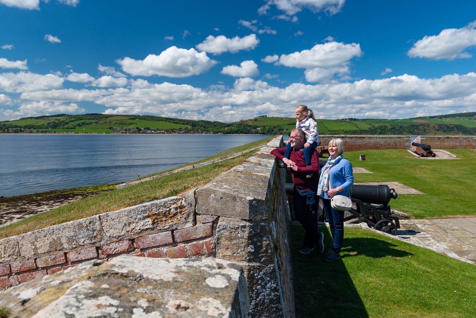 Family of grandparents and grandchild visiting Fort George. 