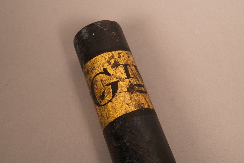 black-on-gold lettering on the end of a ceremonial baton