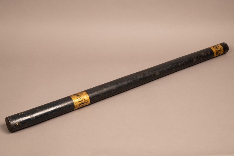 A black baton with gold detail at each end