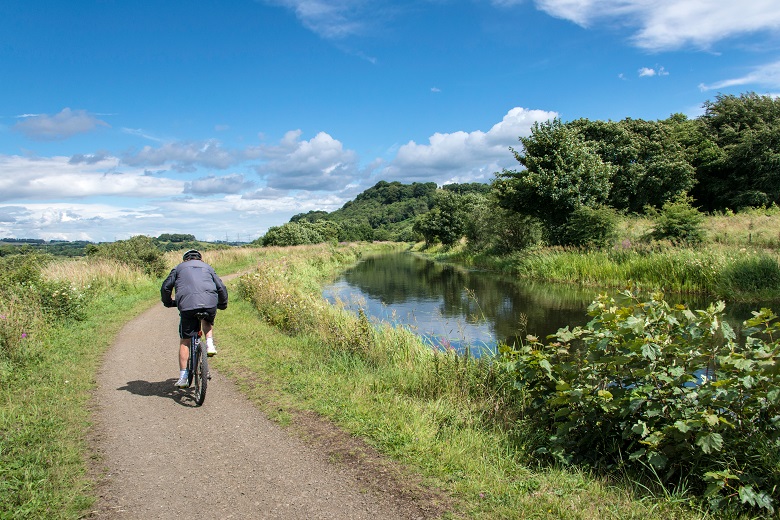 A cyclist on a canal towpath