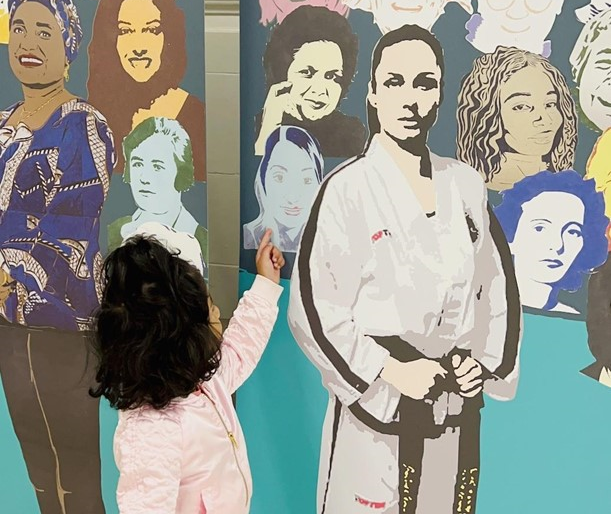 A toddler pointing to an image on an art mural