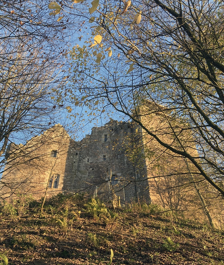 View of Doune Castle through the autumnal trees.