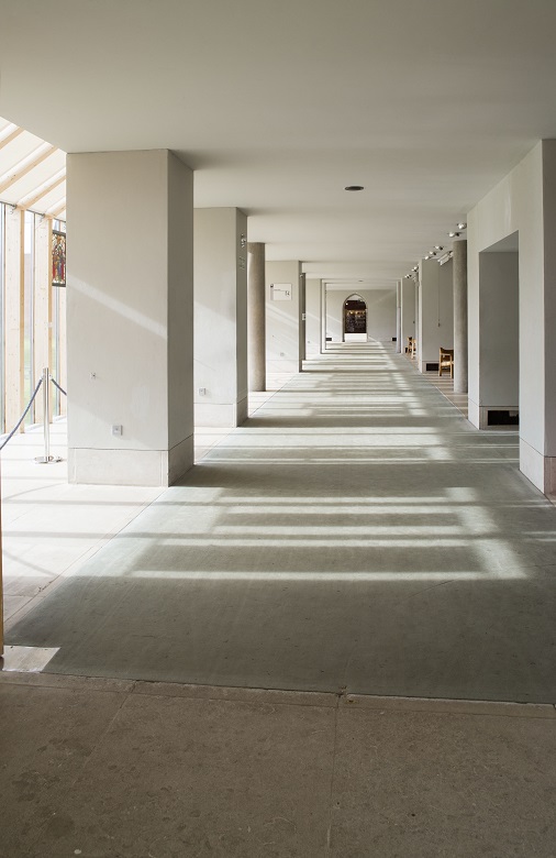 Sunlight flooding into a wide corridor in a gallery building 