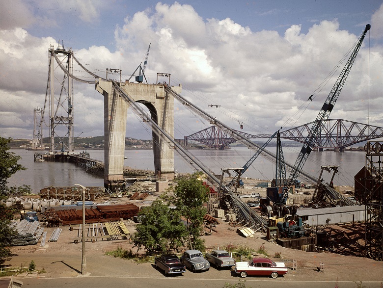 A photo of a building site where a large suspension bridge is under construction 