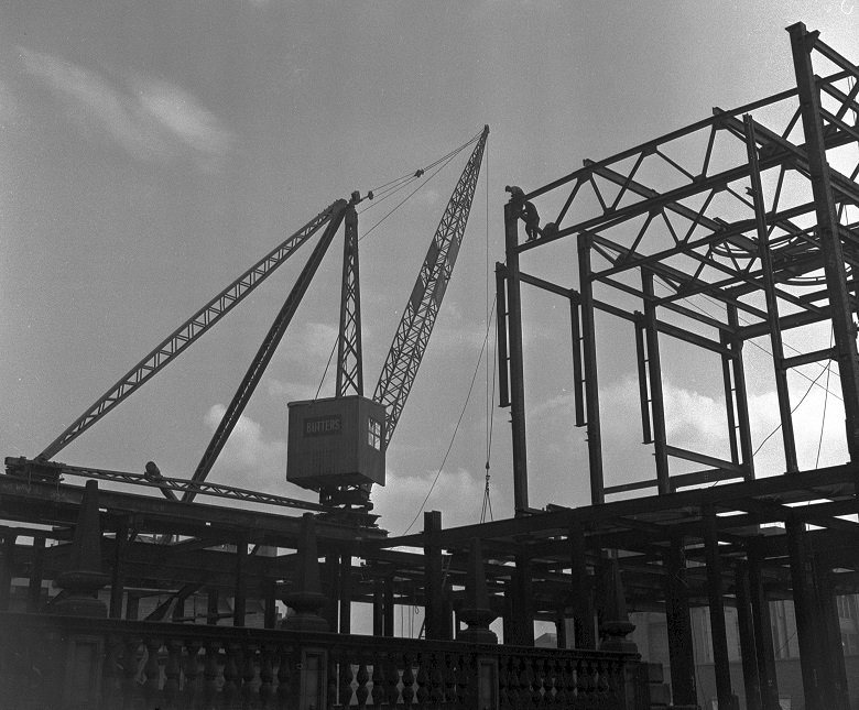 An archive photo of the steel frame of a building under construction 