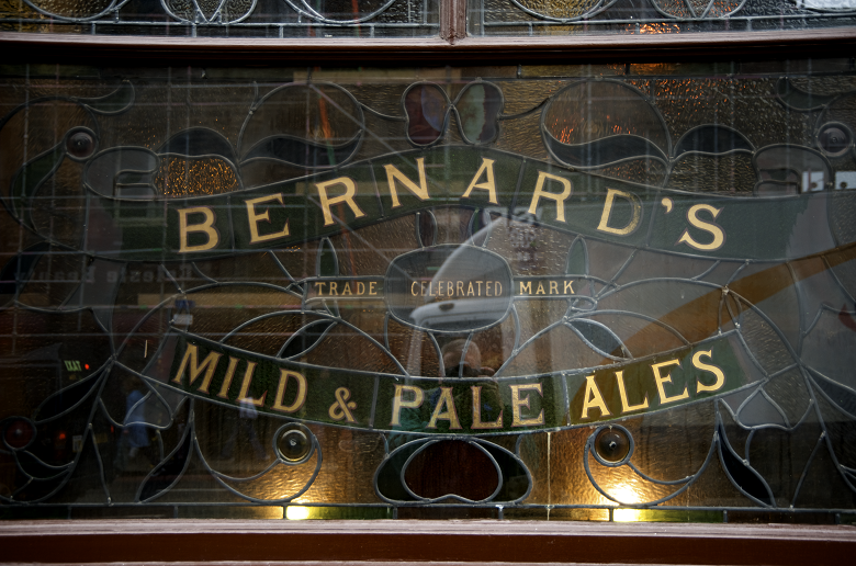 A stained glass window at a pub advertising Bernard's mild and pale ales